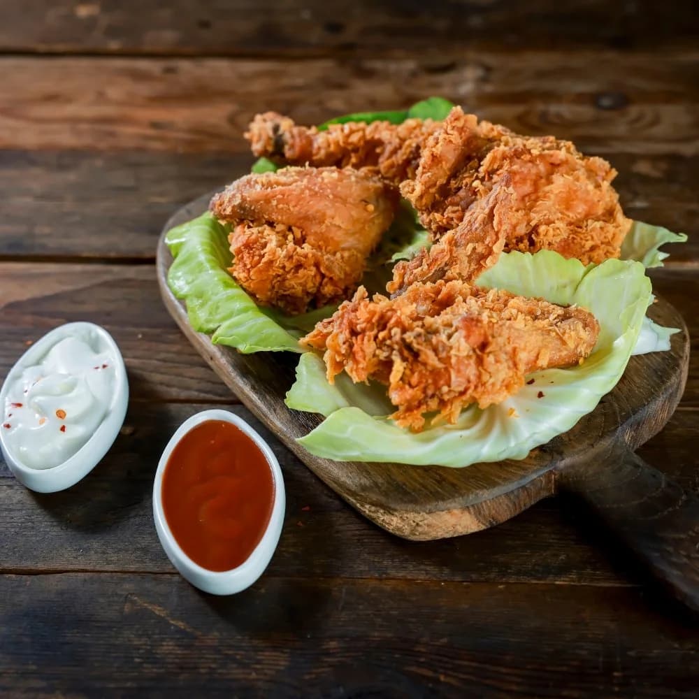 Fried chicken pieces on lettuce with dips